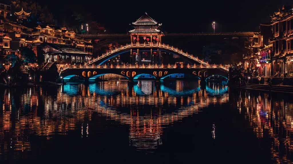 Ville ancienne chinoise illuminée au bord d'une rivière