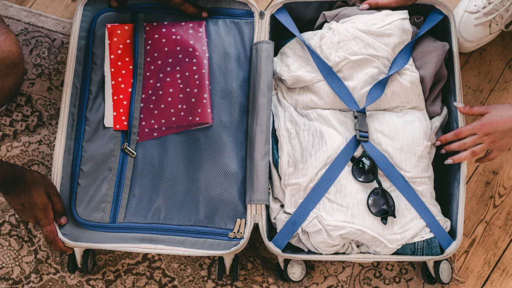 Valise ouverte avec vêtements et accessoires de voyage